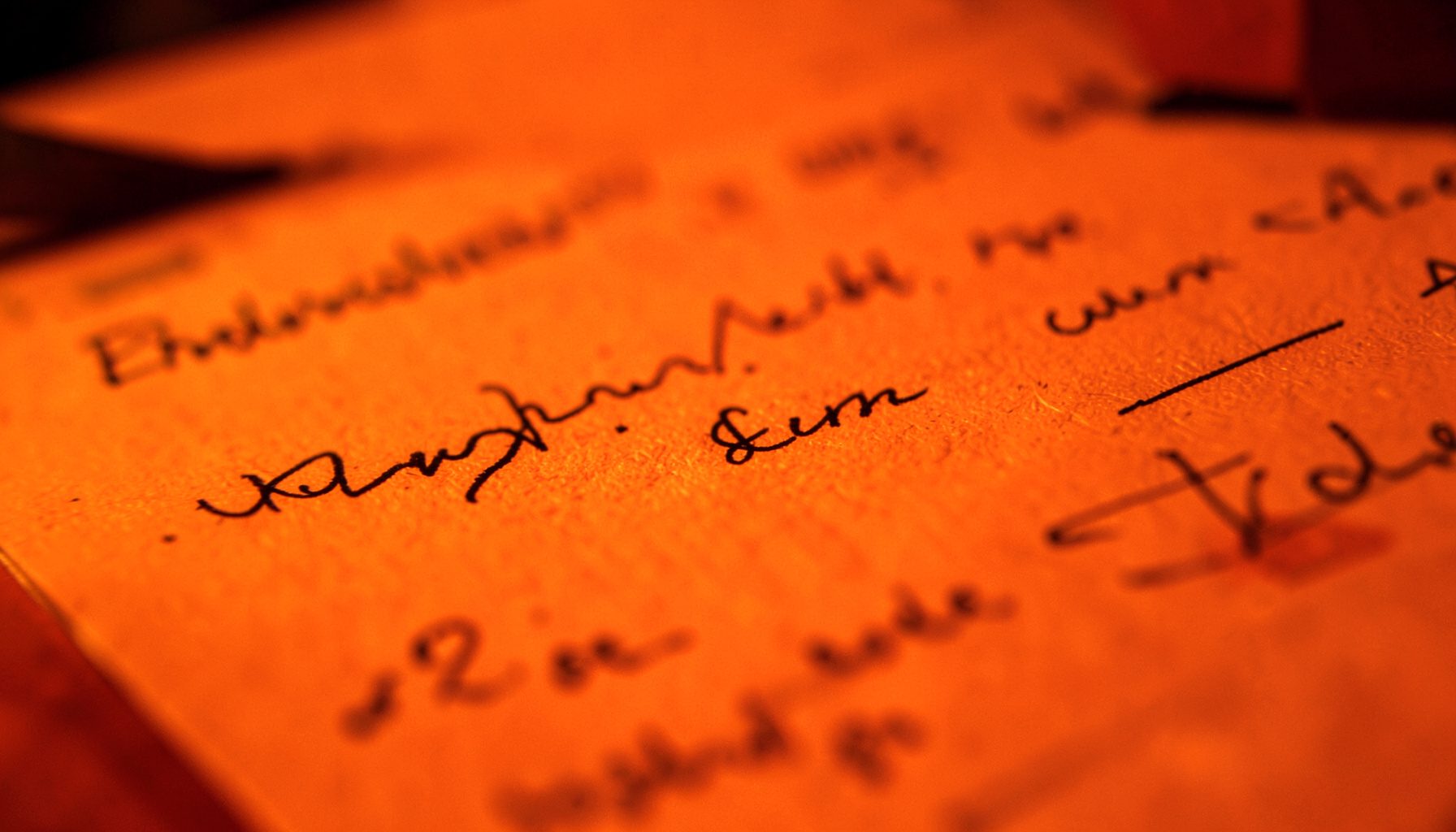 Close-up of a script page with handwritten notes under warm low light, creative atmosphere